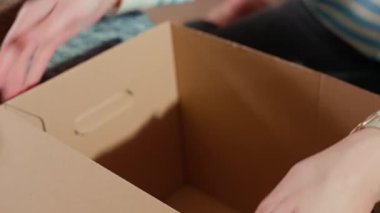 Evde bağış etiketli karton kutunun yanında kullanılmış giysiler. Sadaka, nezaket ve sosyal sorumluluk kavramı