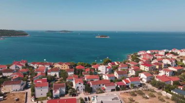 Mavi deniz kenarındaki yerleşim yerlerinin bulunduğu kıyı kasabasının havadan görünüşü. Deniz kenarındaki köyde Akdeniz evleri. Rogoznica, Hırvatistan