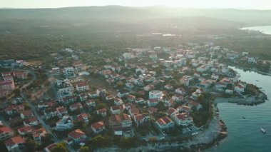 Sakin mavi kıyı şeridi boyunca geleneksel evleri olan kıyı köyünün havadan görünüşü. Adriyatik Denizi ve küçük bir kasabayla Akdeniz manzarası. Hırvatistan 'ın Rogoznica kentinin manzarası