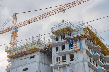 İnşaatı tamamlanmamış çok katlı bina iskelesi ve vinçleri var. Modern kentsel gelişim, çağdaş mimari ve inşaat endüstrisi kavramı