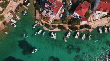 Sahil boyunca demirlemiş küçük tekneleri olan kıyı köyünün havadan görüntüsü. Hırvatistan 'ın Adriyatik Denizi kıyısındaki Rogoznica turizm kasabası. Yaz yolculuğu konsepti