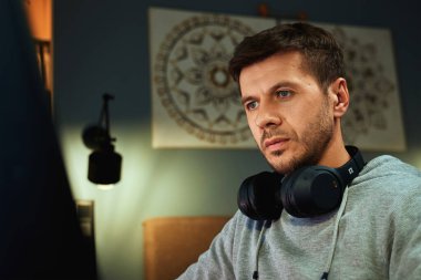 Masada oturan ve bilgisayar ekranına bakan bir adam. Freelancer uzaktan çalışırken ekrana odaklandı. Konsantrasyon, verimlilik ve dijital serbest çalışma kavramı