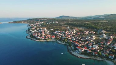 Küçük sahil kasabasının havadan görünüşü. Adriyatik kıyı şeridi boyunca yerleşim binaları ve mavi denizi olan deniz kenarı köyü. Seyahat ve yaz tatili konsepti