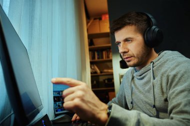 Masada oturan ve bilgisayar ekranına bakan bir adam. Freelancer uzaktan çalışırken ekrana odaklandı. Konsantrasyon, verimlilik ve dijital serbest çalışma kavramı