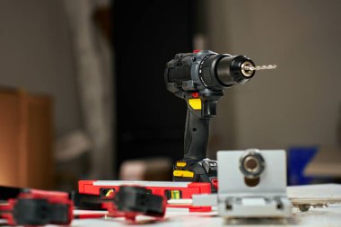 Elektrik kablosuz matkabı ve el aletleri atölyedeki tezgahta. Ev yenileme, inşaat ve onarım konsepti