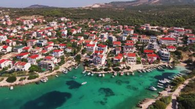 Geleneksel evleri, yeşil tepeleri ve turkuaz denizi olan küçük bir kasabanın havadan görünüşü. Adriyatik kıyı şeridi yakınlarındaki kıyı köyü. Hırvatistan 'ın Rogoznica kentinin manzarası