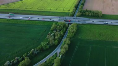 Yeşil tarım arazisi olan kırsal alanda otoyol trafiğinin hava görüntüsü