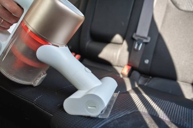 Araba koltuğunu kablosuz elektrik süpürgesiyle temizleyin. Aracın içini temizleme işlemi. Rahat sürüş arabası için günlük temizlik