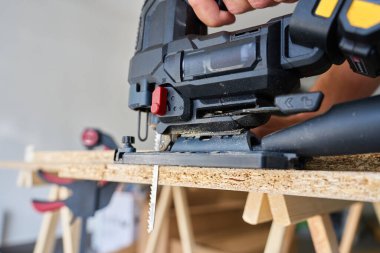 Atölyede ahşap tahta kesen elektrikli el testeresini kapat. El işi aletleri. Marangozluk ve marangozluk