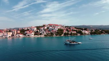 Kıyı kasabası yakınlarında yamaç binaları olan bir balıkçı teknesi. Akdeniz yaşam tarzı ve yaz turizmi kavramı