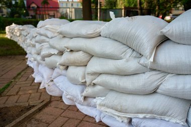 Şehir caddesinde sıralar dolusu kum torbası sel bariyeri olarak istiflenmiş. Fırtınalar, sağanak yağış ve selleri önlemek için acil durum koruma önlemi