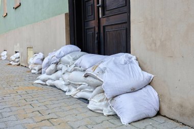 Kum torbaları binayı sel suyundan korumak için kapının önüne istiflenmiş. Kentsel yerleşim alanındaki fırtına hasarı ve doğal afete karşı acil savunma tedbirleri