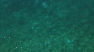 Sakin ve dalgalı mavi deniz yüzeyindeki İHA uçuşunun yukarıdan aşağıya doğru görüntüsü