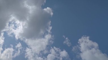 Gün ışığında dağınık bulutları hareket ettiren mavi gökyüzünün zamanı. Atmosfer koşulları ve değişen hava konsepti