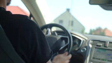 Güneşli bir günde araba süren bir adam, içeriden. Sürücü elleri direksiyonda. Seyahat ve yolculuk konsepti