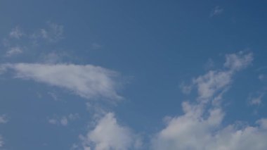 Gün ışığında dağınık bulutları hareket ettiren mavi gökyüzünün zamanı. Atmosfer koşulları ve değişen hava konsepti