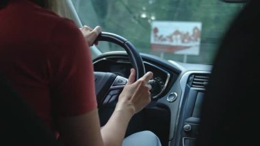 Şehirde modern araba kullanırken direksiyon tutan kadın. Kadın sürücü aracı kontrol ediyor, içeriden. Güvenli sürüş ve modern yaşam tarzı konsepti