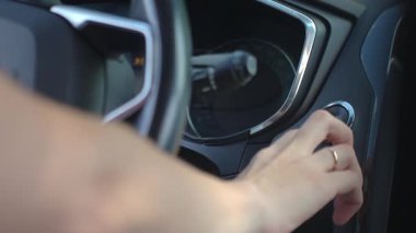 Otomobil motorunu çalıştırmak için elinle başlat düğmesine bas. Modern arabada anahtarsız ateşleme sistemi