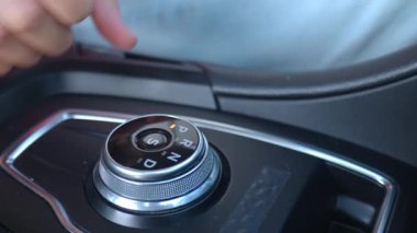 Modern araba iç mekanında el vites kolu yakın plan. Sürücü otomatik vites kutusunda sürücü kipinde iletimi değiştirir