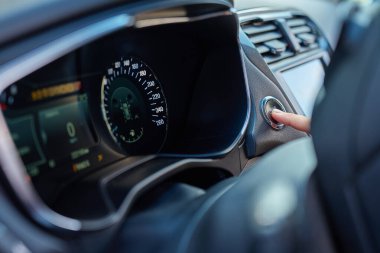 Otomobil motorunu çalıştırmak için elinle başlat düğmesine bas. Modern arabada anahtarsız ateşleme sistemi