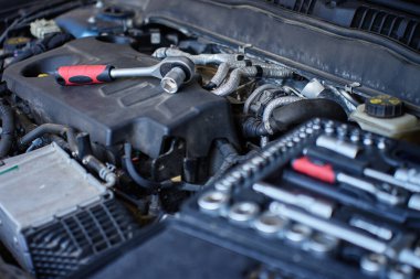 Bakım sırasında araba motorunun üzerinde duran anahtar soketinin yakın çekimi. Araç tamir kavramı