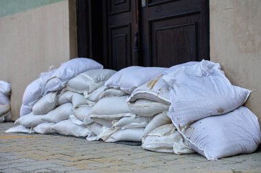 Kum torbaları binayı sel suyundan korumak için kapının önüne istiflenmiş. Kentsel yerleşim alanındaki fırtına hasarı ve doğal afete karşı acil savunma tedbirleri