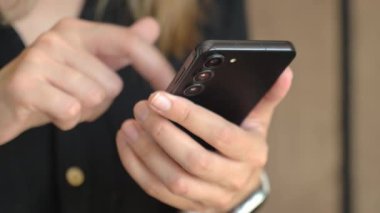 Bir kadının cep telefonuyla dokunmatik ekranı dinlerken modern akıllı telefonu kullanmasına yakın çekim. Teknoloji kavramı, mobil iletişim ve günlük dijital yaşam