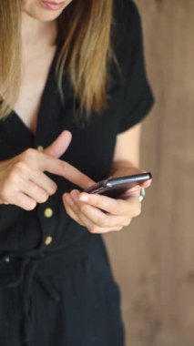 Bir kadının cep telefonuyla dokunmatik ekranı dinlerken modern akıllı telefonu kullanmasına yakın çekim. Teknoloji kavramı, mobil iletişim ve günlük dijital yaşam