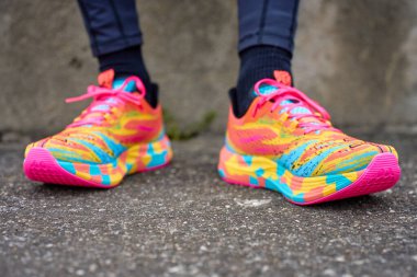 Kaldırım kenarında parlak tabanlı renkli koşu ayakkabıları giyen birine yaklaş. Fitness kavramı, aktif yaşam tarzı ve eğitim veya açık hava egzersizi