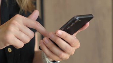 Bir kadının cep telefonuyla dokunmatik ekranı dinlerken modern akıllı telefonu kullanmasına yakın çekim. Teknoloji kavramı, mobil iletişim ve günlük dijital yaşam