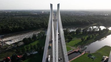 Nehir üzerindeki trafik ve çevre tarlalarla modern kablo destekli köprünün havadan görünüşü. Wroclaw, Polonya 'da Redzinski köprüsünde araba sürüyor. Ulaşım ve kentsel altyapı kavramı