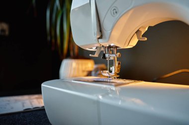 Dikiş makinesi iğnesinin yakın görüntüsü ve iplikli baskılı ayak. Dikiş ve el yapımı zanaat kavramı