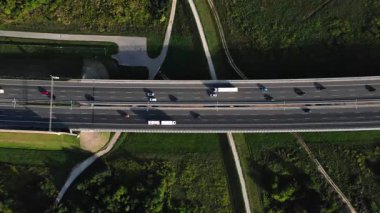 Yeşil tarlalarla çevrili otoban köprüsünün havadan görünüşü. Ulaşım ve modern yol altyapısı kavramı