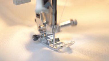 Dikiş makinesi iğnesinin yakın görüntüsü ve iplikli baskılı ayak. Dikiş ve el yapımı zanaat kavramı