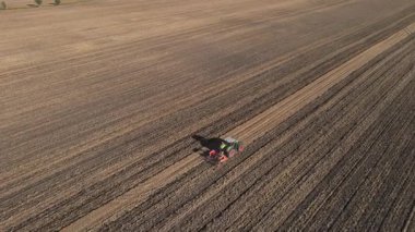 Tarımsal alanda çalışan yeşil traktör, kuru toprak ekip biçiyor, hava manzarası var. Tarım sektörü konsepti. Küçük tarım kavramı