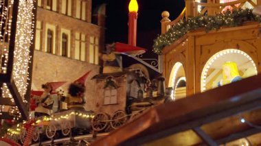 Oyuncak trenle gezen ışıklı cüce figürleriyle, gece vakti festival ışıklarıyla ve tatil atmosferiyle. Wroclaw, Polonya 'da Noel pazarı