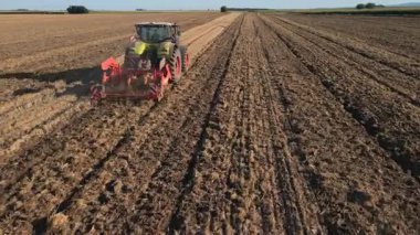 Tarımsal alanda çalışan yeşil traktör, kuru toprak ekip biçiyor, hava manzarası var. Tarım sektörü konsepti. Küçük tarım kavramı