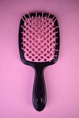 Masaj fırçası, pembe arka planda saç fırçası. Yakın plan..