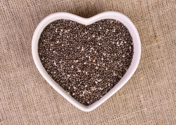 stock image Chia seeds in a heart-shaped plate. Flat lay.