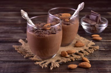 Koyu ahşap arka planda badem kaplı çikolatalı mus..