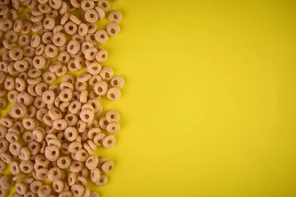 Cereal rings for breakfast with milk on a yellow background.Copy space.