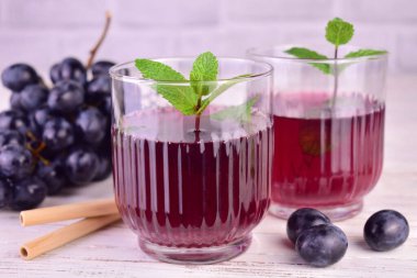  Grape juice in glass glasses on a white background.