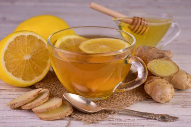 Tea with ginger lemon and honey in a transparent cup.