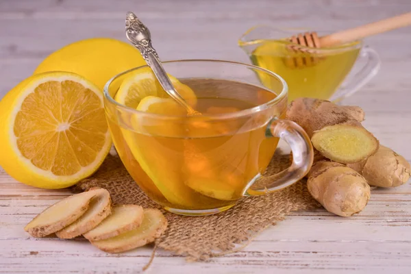 Tea with ginger lemon and honey in a transparent cup.