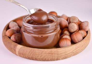 Lezzetli çikolatalı fındık ezmesi ve beyaz arka planda fındık.. 