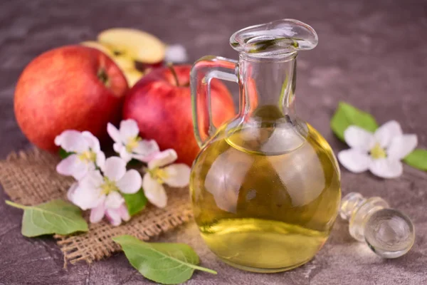 stock image Glass decanter with apple cider vinegar and fresh apples on gray background.