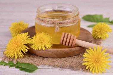 Beyaz arka planda kavanozdaki bahar karahindibalarından taze bal..