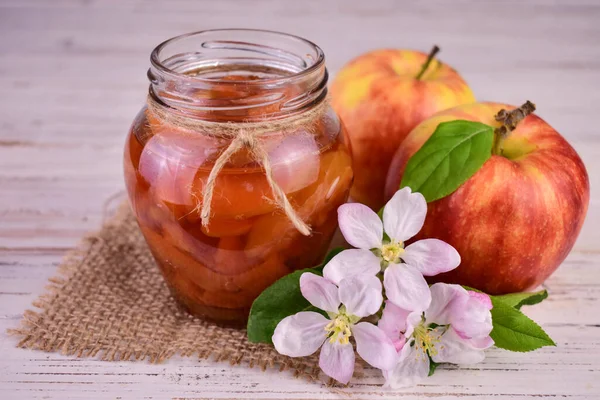 Apple jam in a jar and fresh red apples
