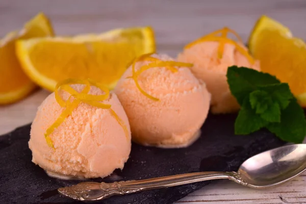 橙子冰淇淋 黑色石板上的橙子冰淇淋球 — 图库照片