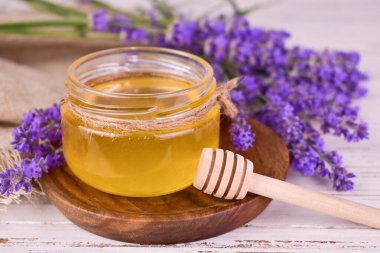 Tahta tepside taze kokulu lavanta balı ve lavanta çiçekleri..